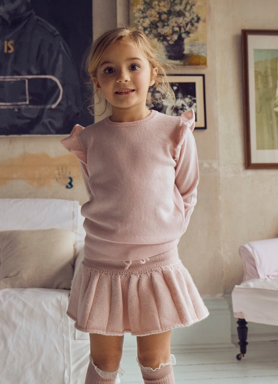 This timeless 2 ply Jumper in Blush Pink comes with a sweet little ruffle on the shoulder for a subtle elegant look. Made with a lovely cashmere/super soft merino blend from Inner Mongolia, it will keep your Little One stylish and warm all winter long. Team it up with our matching pleated Tennis Skirt in Blush Pink for a head-to-toe snuggly feel.