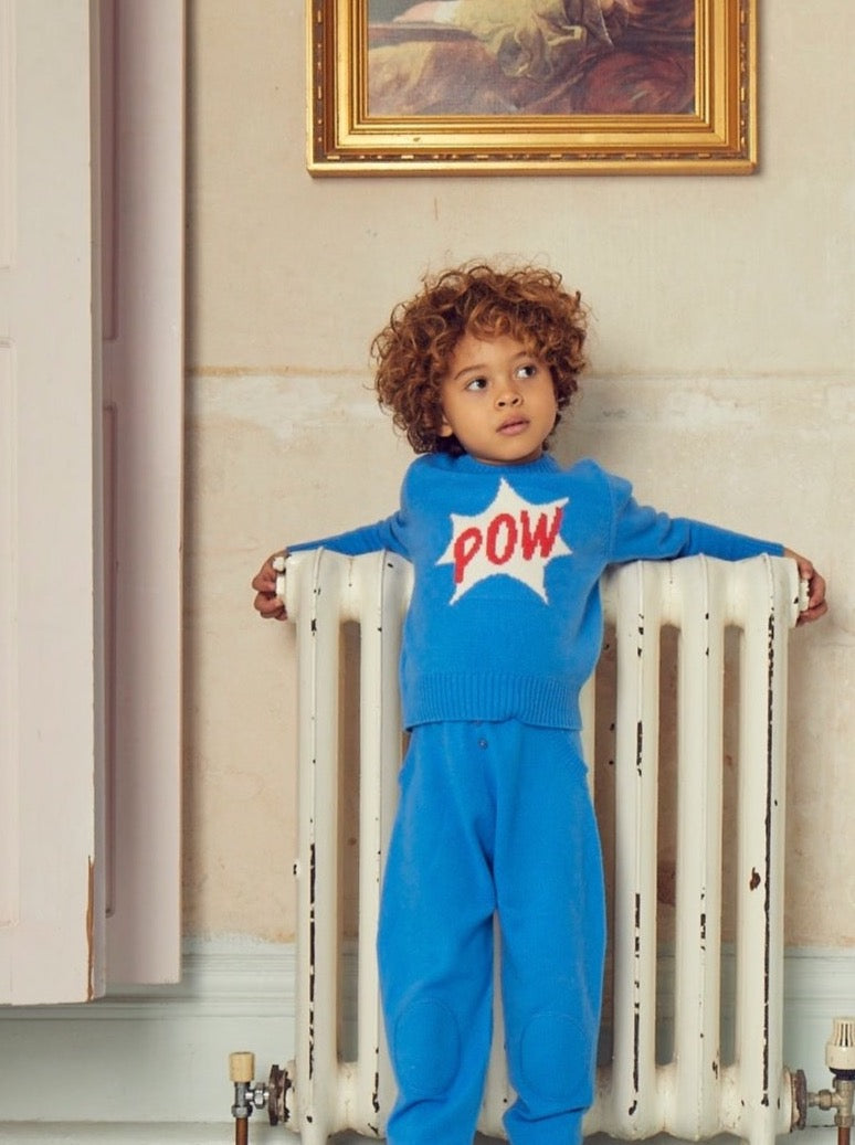 Bang, Crash, Thump: POW. This cosy 4 ply jumper comes with a double collar rib and POW emblazoned across the front super hero style. It will appeal to all young super heroes in the making. Made with the softest cashmere/ merino blend from Inner Mongolia, it will keep you Little One cosy and warm all winter long. Team it up with our matching Boy Pants in Bright Blue for a head-to-toe cosy feel.