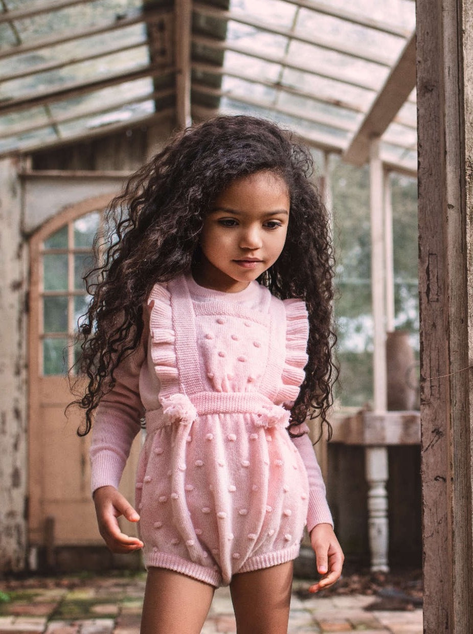 This stylish 4 ply Ruffled Bobble Romper comes with lots and lots of Bobbles. After all, who doesn't love bobbles. It makes a fun addition to any winter wardrobe and comes with 3 buttons holes on the straps so that they can be extended as your Little One grows. Made with the softest cashmere/merino blend from Inner Mongolia, it will keep your Little One cosy and warm all winter long. Team it up with a cosy jumper underneath and a thick pair of tights.