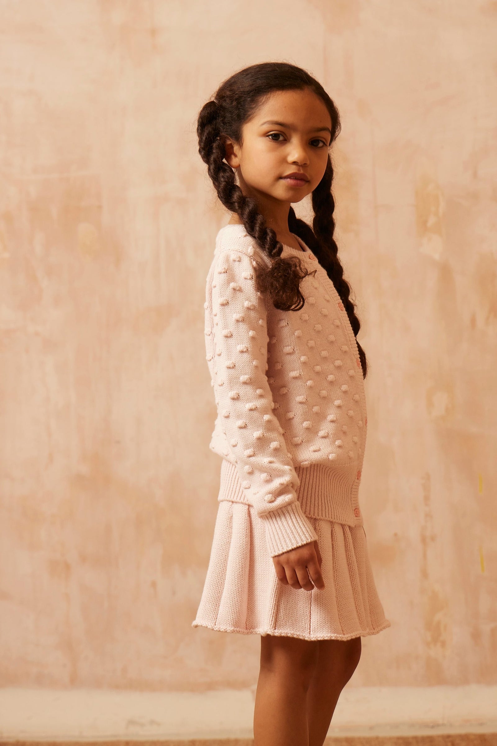 Young girl in a blush pink Popcorn Knit Jumper from MIKA & MILO, soft organic cotton and cashmere with puff sleeves