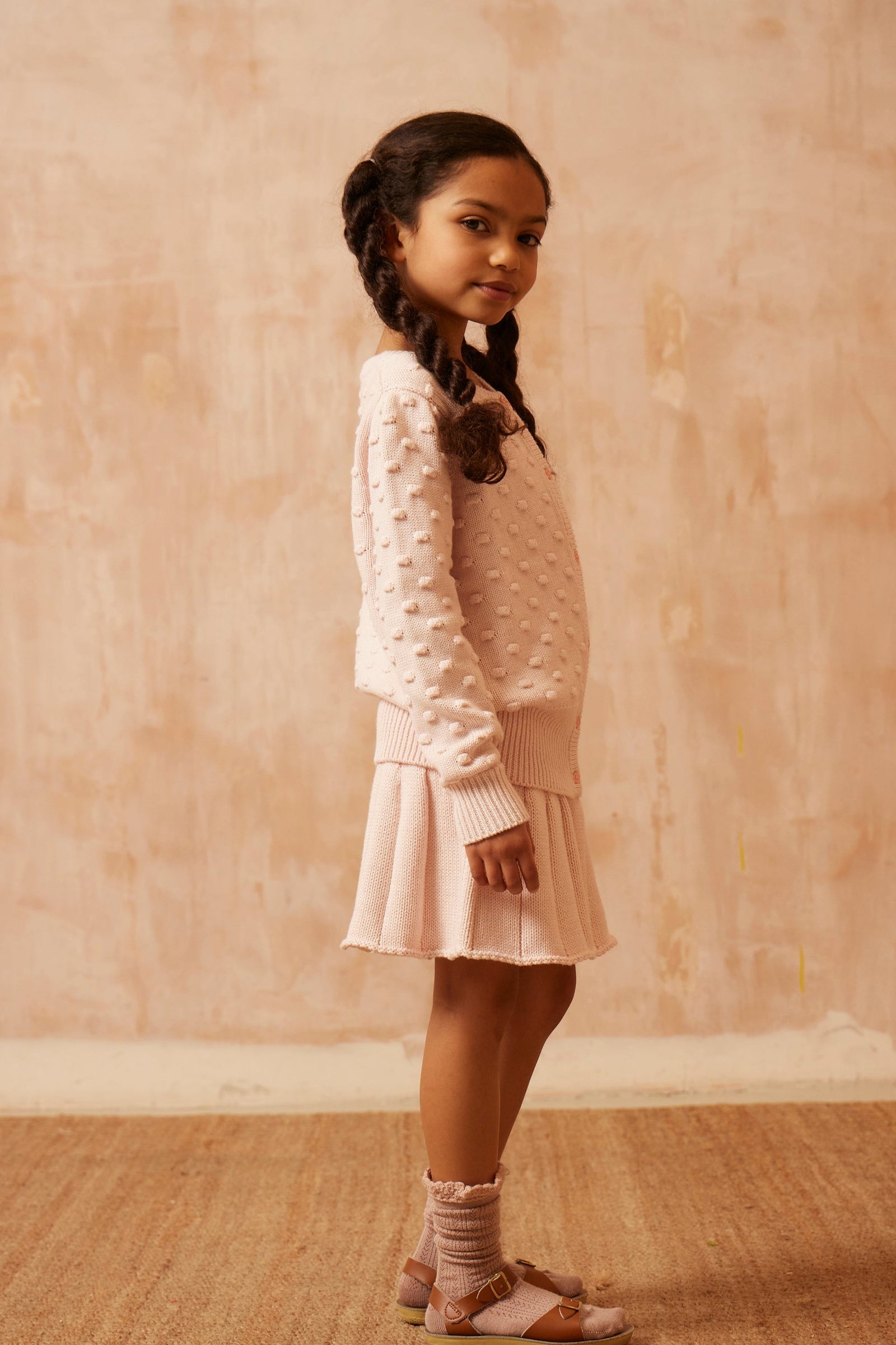 Young girl in a blush pink Popcorn Knit Jumper from MIKA & MILO, soft organic cotton and cashmere with puff sleeves