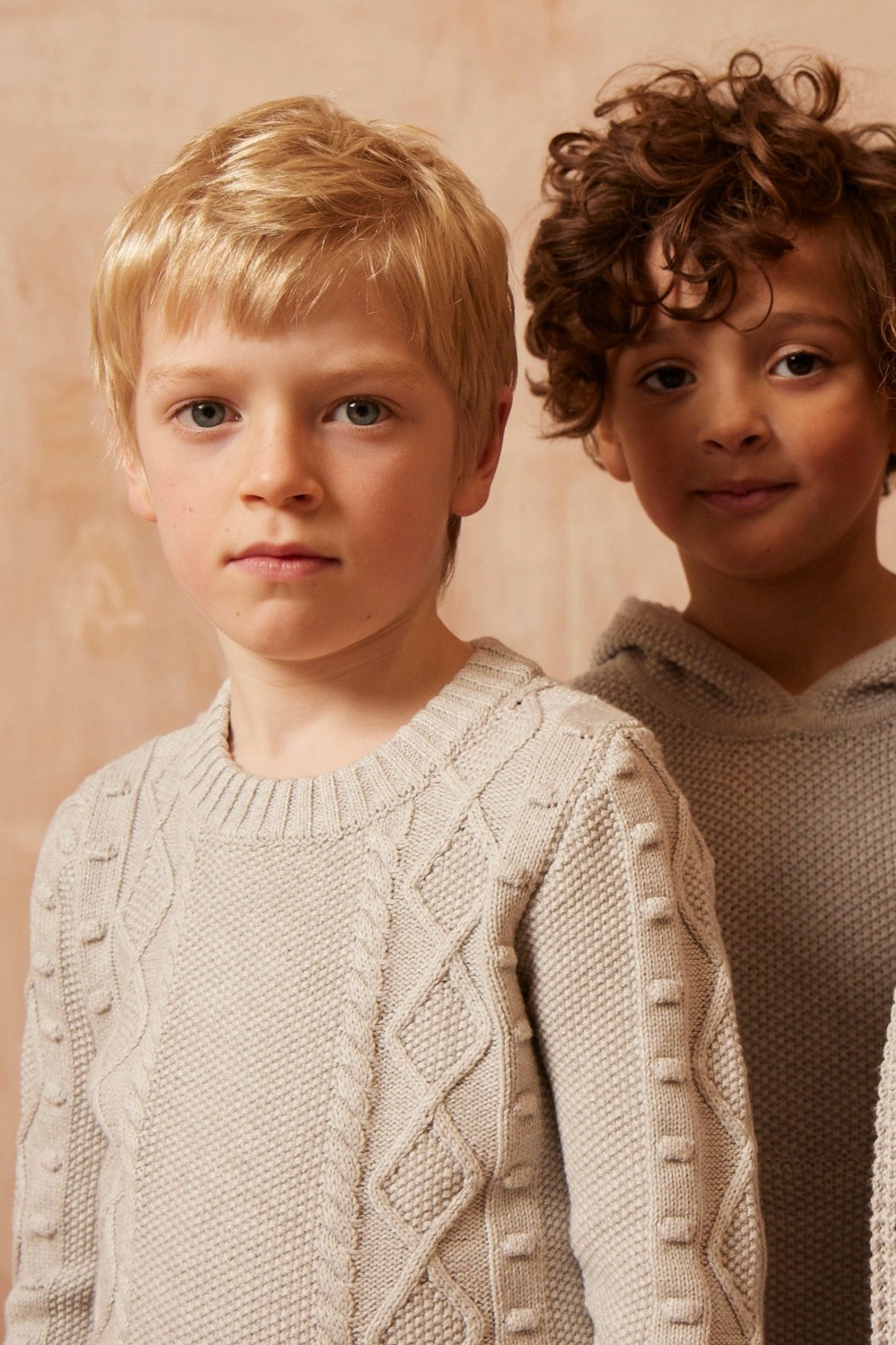 Two boys wearing the grey Popcorn Fisherman Jumper from MIKA & MILO, knitted in organic cotton and cashmere