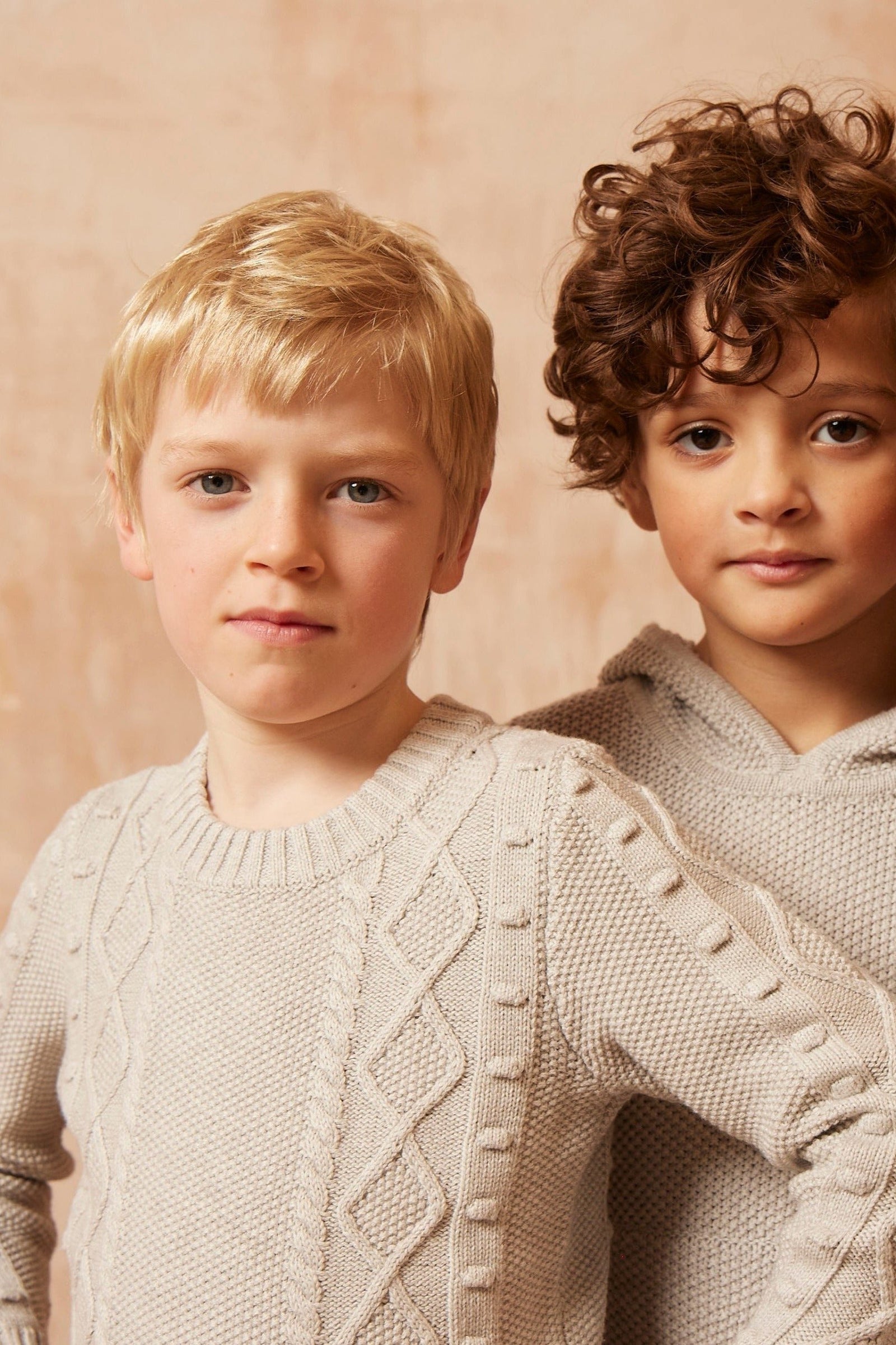 Two boys wearing the grey Popcorn Fisherman Jumper from MIKA & MILO, knitted in organic cotton and cashmere