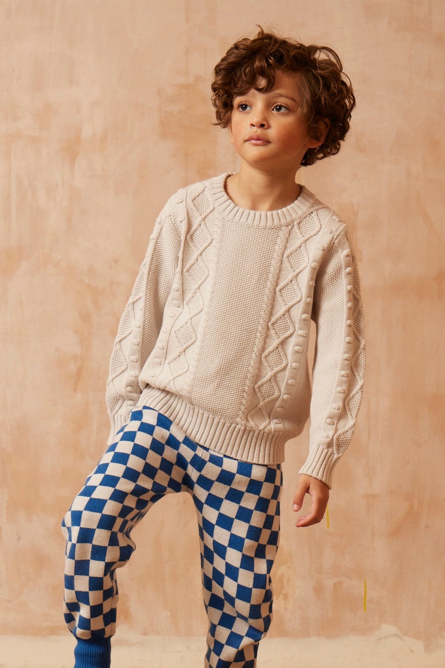 Boy wearing the chalk-white Popcorn Fisherman Jumper from MIKA & MILO, knit in organic cotton and cashmere