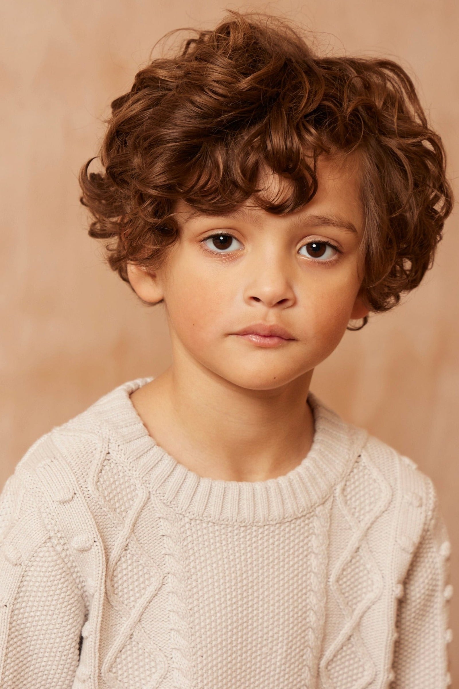 Boy wearing the chalk-white Popcorn Fisherman Jumper from MIKA & MILO, knit in organic cotton and cashmere