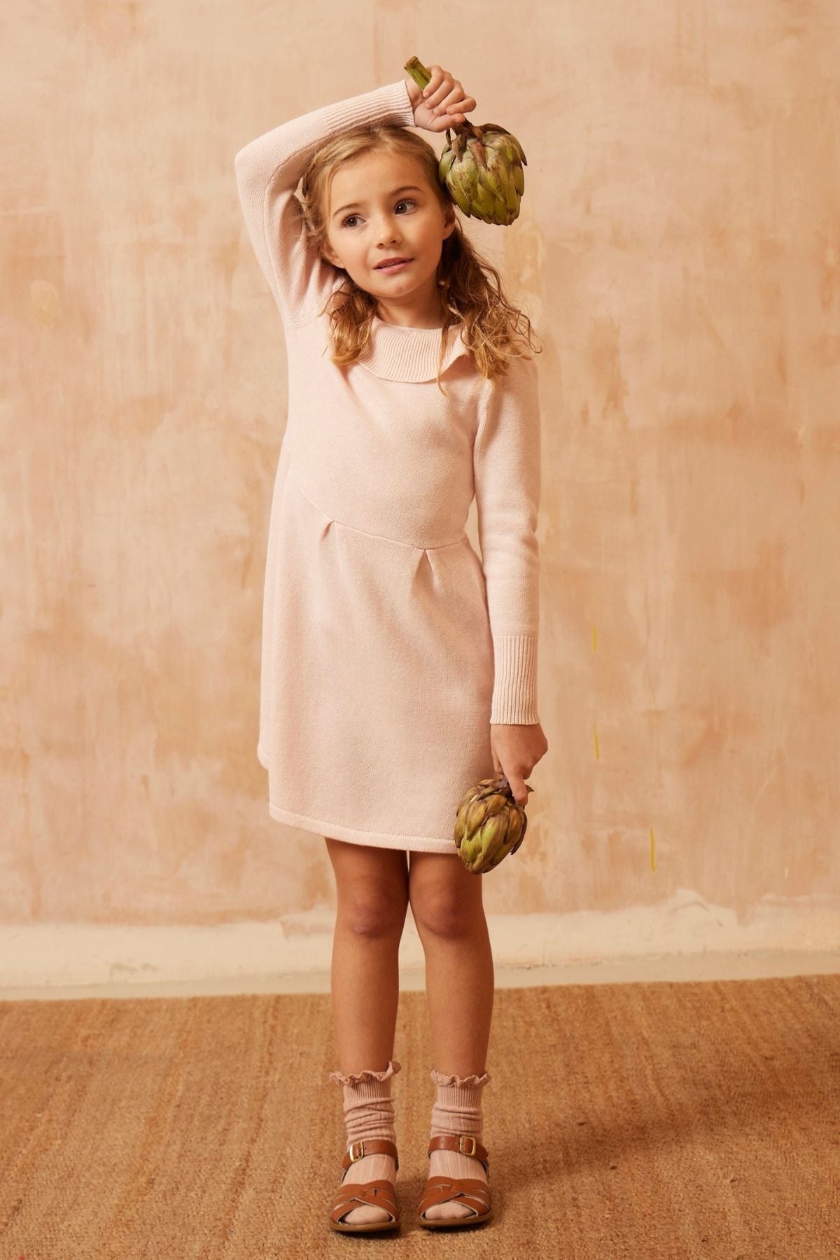 Young girl in the blush Ruffled V Dress from MIKA & MILO, soft organic cotton and cashmere knit with statement collar