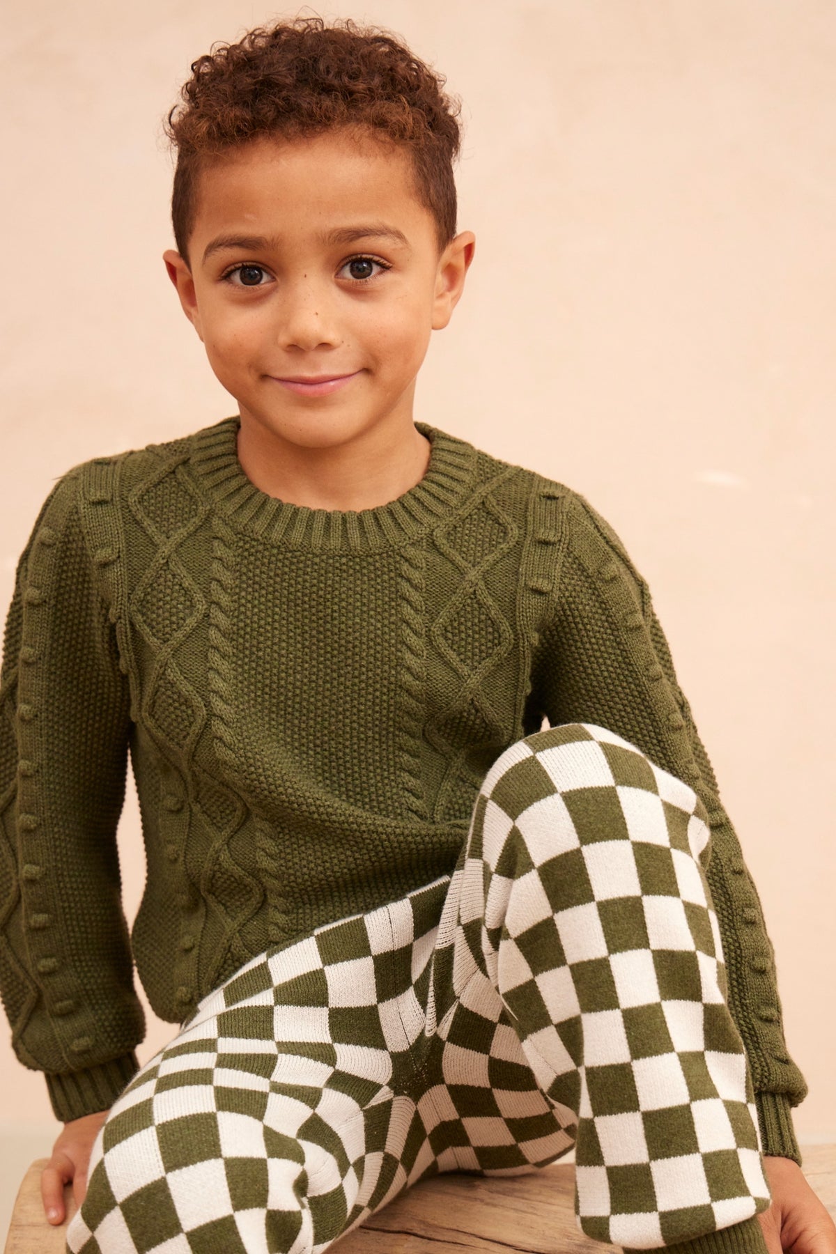 Boy wearing the Cable Popcorn Jumper in avocado green