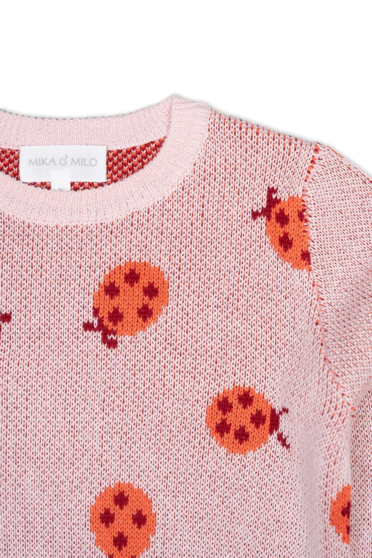 Close-up of the jacquard-knit ladybirds on the rose pink jumper
