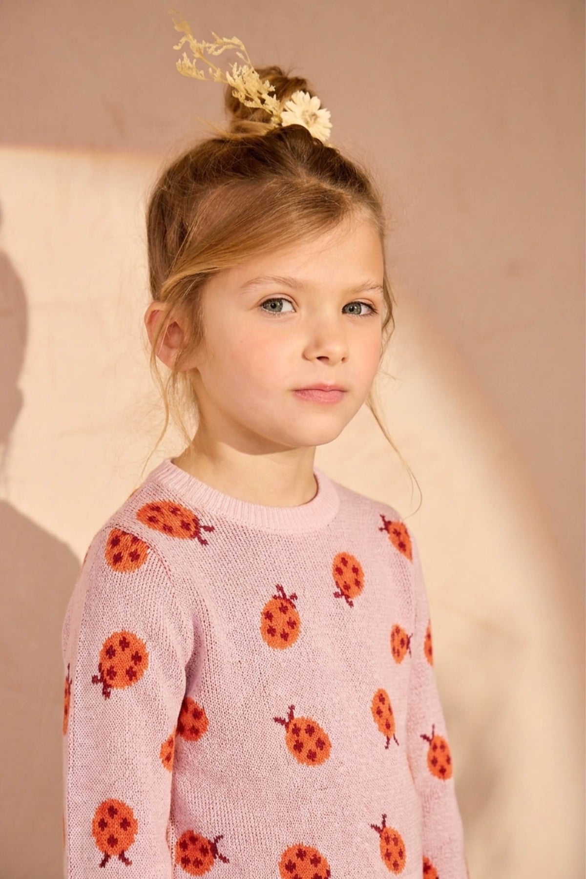 Girl wearing the Ladybird Jumper in rose pink