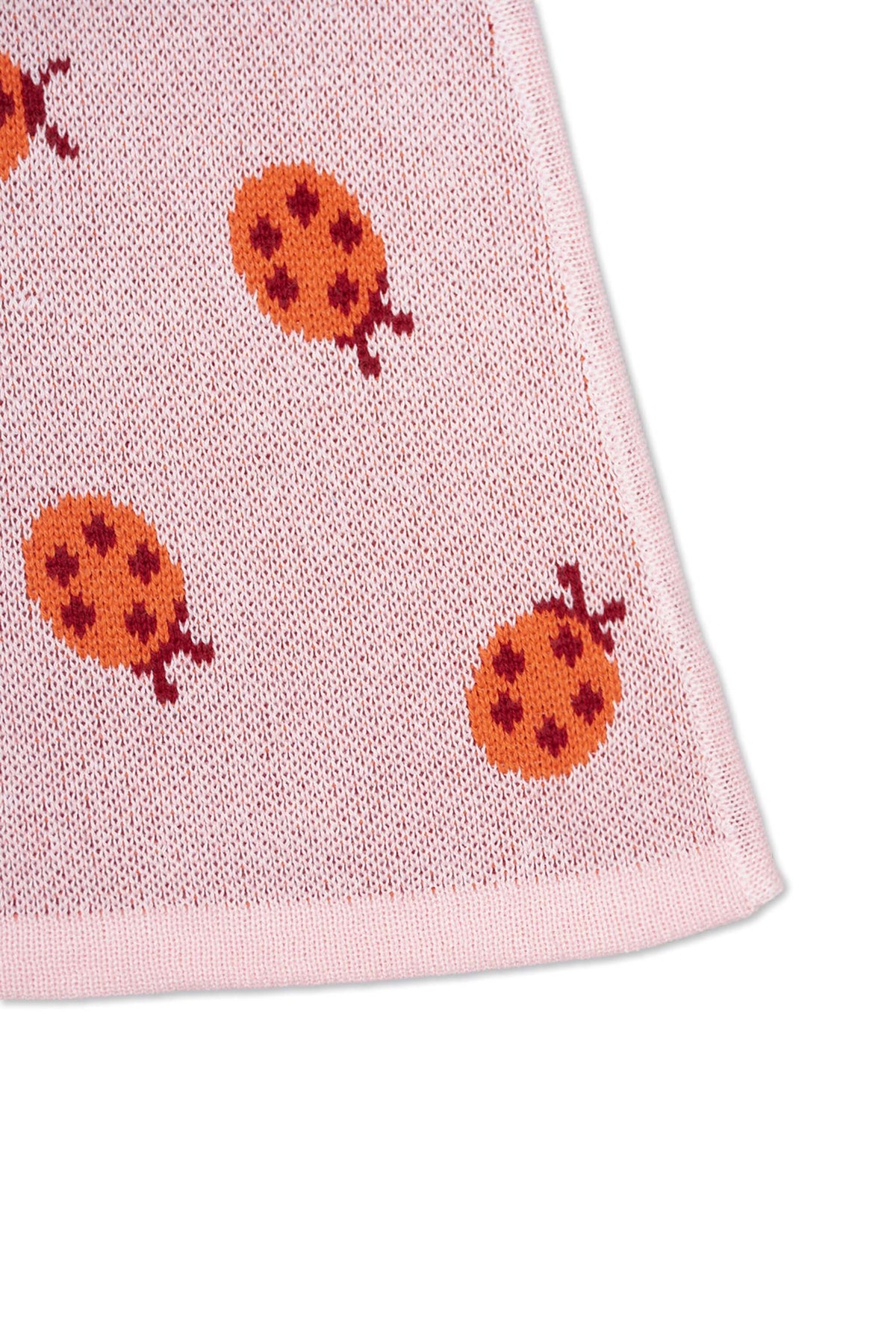 Close-up of the jacquard-knit ladybirds on the rose pink skirt