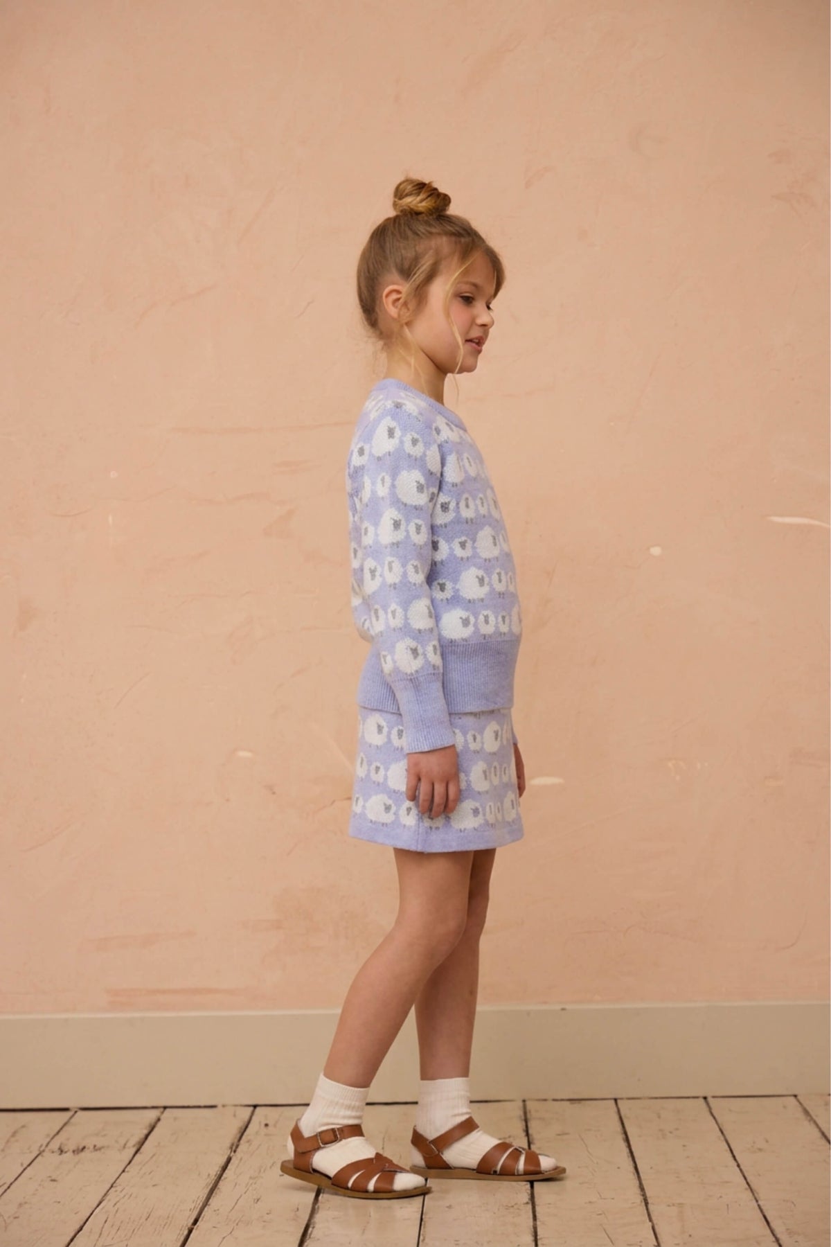 Girl standing in the Little Bo Peep jumper and skirt set in lavender