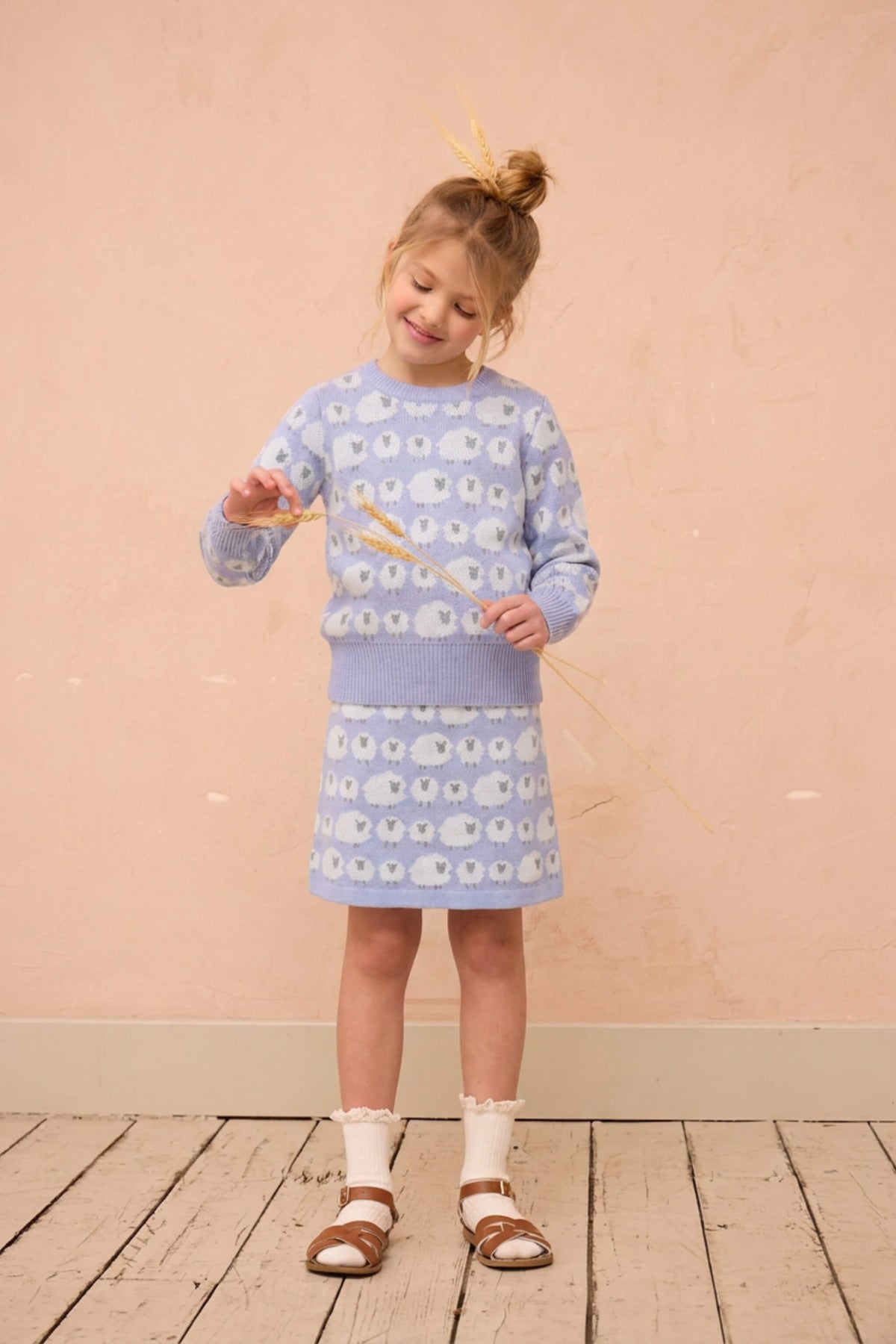 Side view of a girl in the Little Bo Peep jumper and skirt in lavender