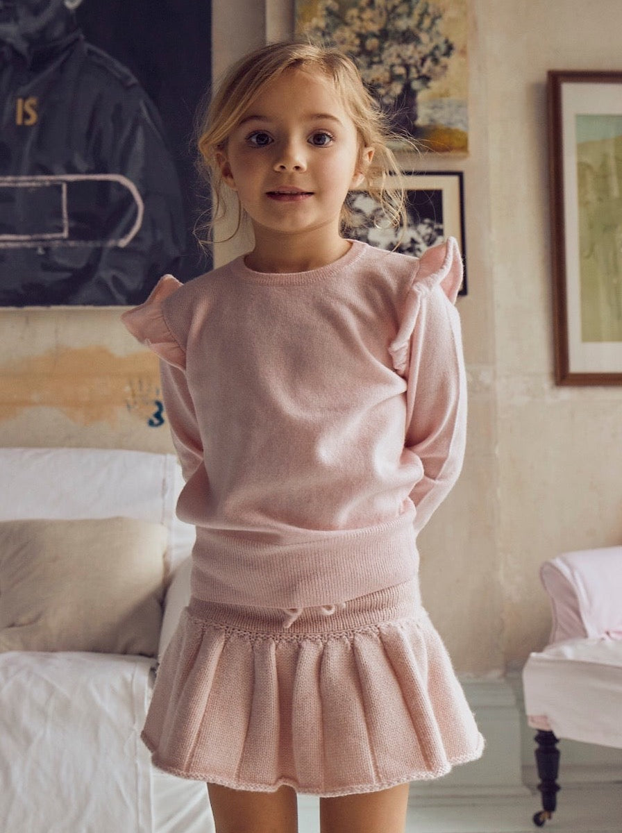 This timeless 2 ply Jumper in Blush Pink comes with a sweet little ruffle on the shoulder for a subtle elegant look. Made with a lovely cashmere/super soft merino blend from Inner Mongolia, it will keep your Little One stylish and warm all winter long.   Team it up with our matching pleated Tennis Skirt in Blush Pink for a head-to-toe snuggly feel. 