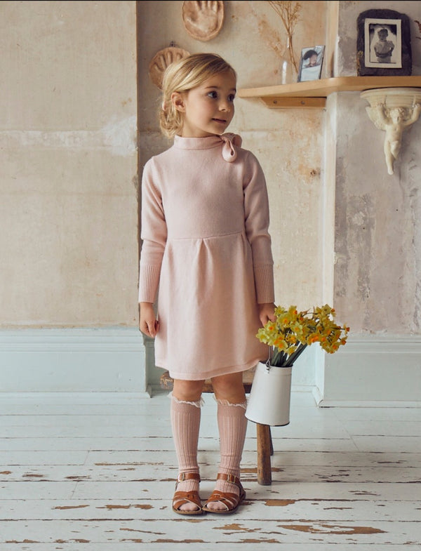 This timeless 2 ply dress in Blush Pink comes with a classic Pussy Bow. It also comes with Pleats at the waistline for added femininity. Made with the softest cashmere/ merino blend from Inner Mongolia, it will keep your Little One stylish and warm all winter long. 